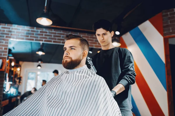 Stilvoller Mann sitzt in einem Friseurladen — Stockfoto