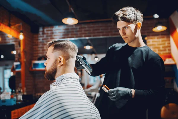 Stilvoller Mann sitzt in einem Friseurladen — Stockfoto