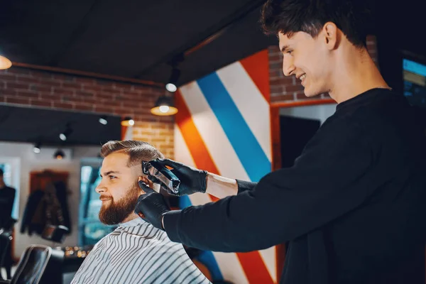 Stilvoller Mann sitzt in einem Friseurladen — Stockfoto