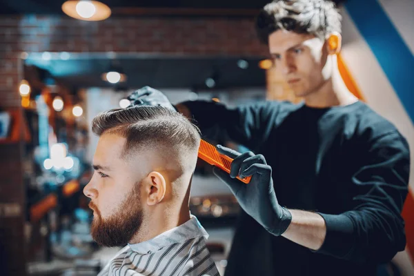 Stilvoller Mann sitzt in einem Friseurladen — Stockfoto