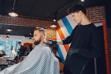 Berber dükkanında oturan şık bir adam.