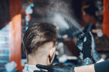 Berber dükkanında oturan şık bir adam.