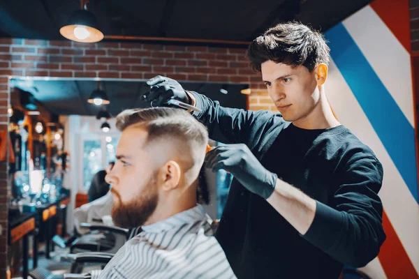 Stilvoller Mann sitzt in einem Friseurladen — Stockfoto