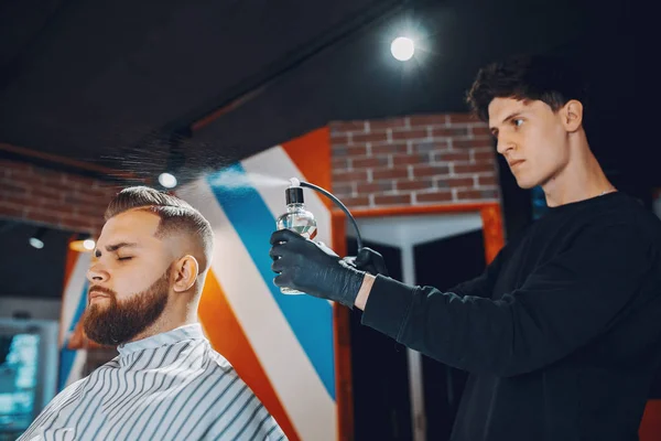 Elegante hombre sentado en una barbería — Foto de Stock