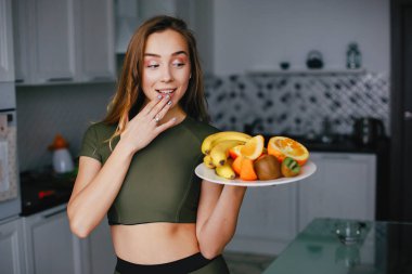 Spor kız sebze ile mutfakta