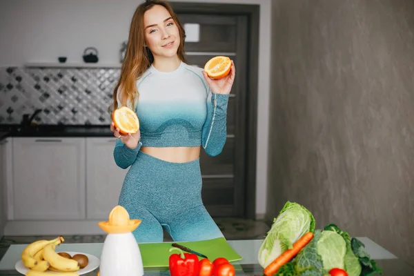 Menina de esportes em uma cozinha com legumes — Fotografia de Stock