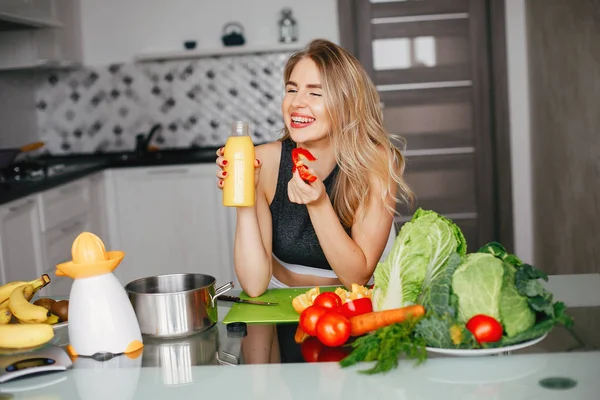 Sportmädchen in einer Küche mit Gemüse — Stockfoto