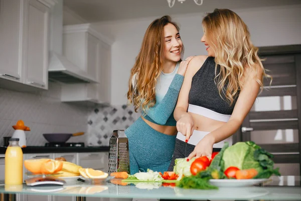 Deux sportives dans une cuisine avec des légumes — Photo