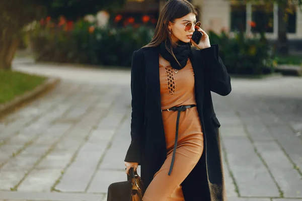 Snygg flicka promenader genom staden när du använder sin telefon — Stockfoto