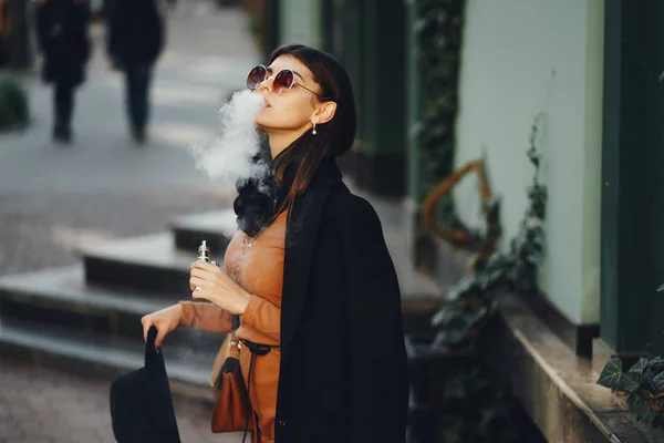 Ragazza elegante fumare una sigaretta elettronica — Foto Stock