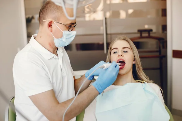 Schöne Mädchen sitzen in der Zahnarztpraxis — Stockfoto