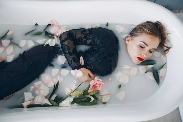 Tyylikäs ja kaunis tyttö makaa kylpyhuoneessa — kuvapankkivalokuva