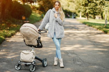 genç anne bebek arabasını iterek