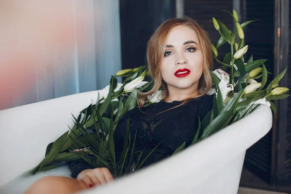 Stylish and beautiful girl lies in the bathroom — Stock Photo, Image