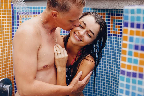 Elegante pareja de pie bajo la ducha —  Fotos de Stock