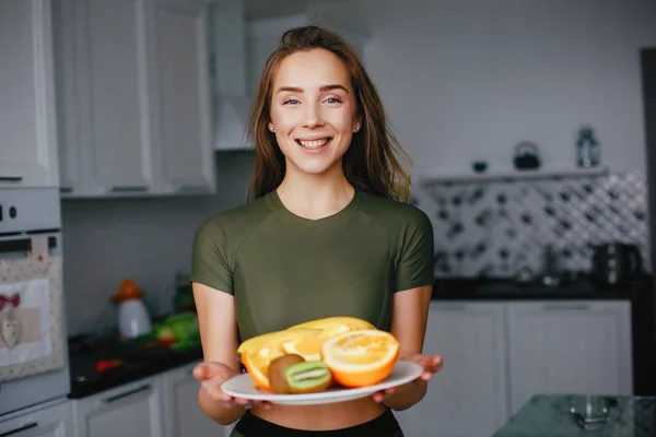 Спортивная девушка на кухне с овощами — стоковое фото