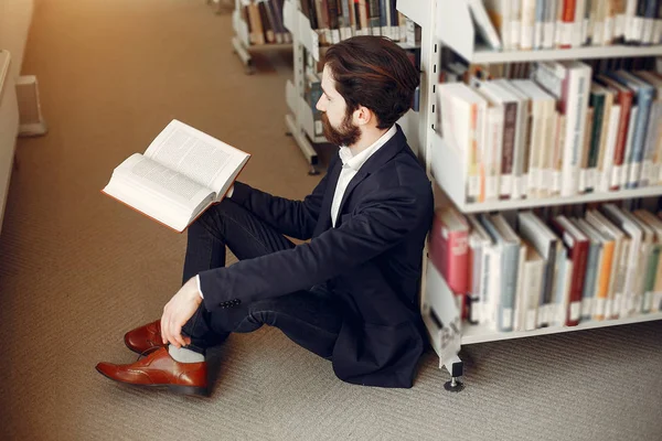 Красивий хлопець навчається в бібліотеці — стокове фото