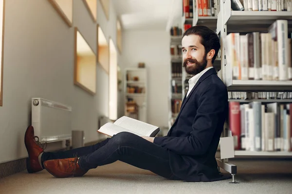 Knappe kerel studeren in de bibliotheek — Stockfoto