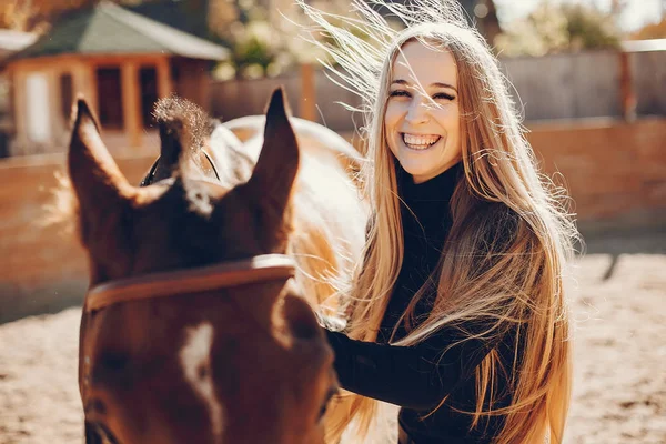 Elegants meisje met een paard in een ranch — Stockfoto