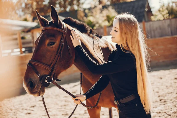 Menina elegante com um cavalo em um rancho — Fotografia de Stock