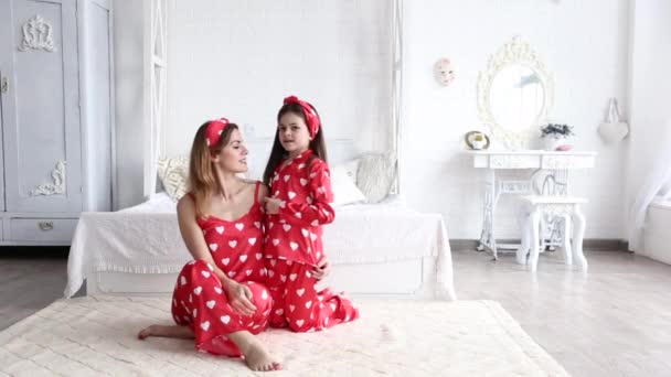 Video of mother and daughter playing in the bedroom in matching pajamas — Stock Video