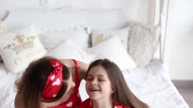 eşleşen pijama içinde yatak odasında oynayan anne ve kızı video