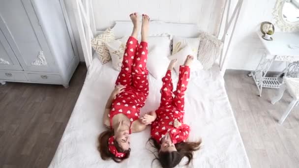 お揃いのパジャマで寝室で遊ぶ母と娘のビデオ — ストック動画
