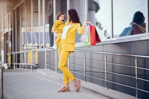 在城市里带购物袋的母亲和女儿 — 图库照片