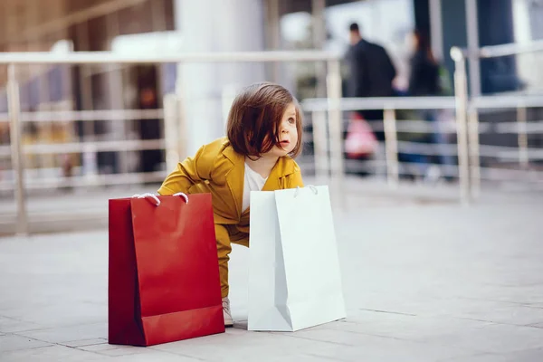 Linda niña con bolsa de compras en una ciudad — Foto de Stock