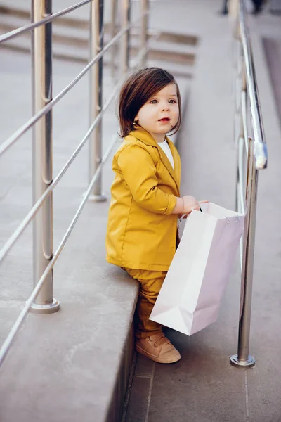 Linda niña con bolsa de compras en una ciudad — Foto de Stock