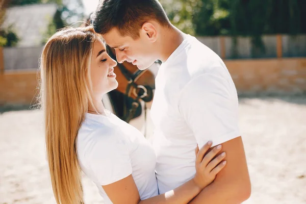 Beautiful couple spend time with a horses — Stock Photo, Image