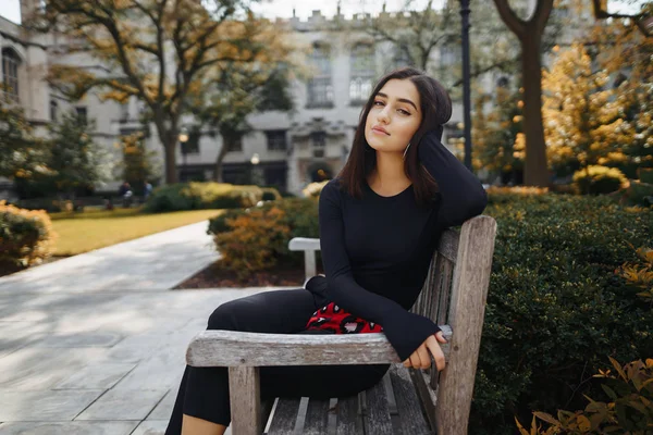 Okulda bir bankta oturan şık kız — Stok fotoğraf
