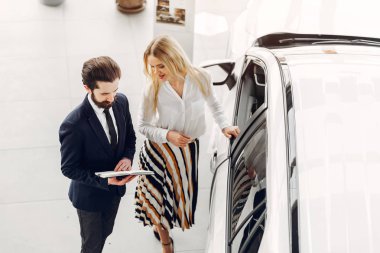 Bir araba galerisinde şık ve zarif bir kadın.