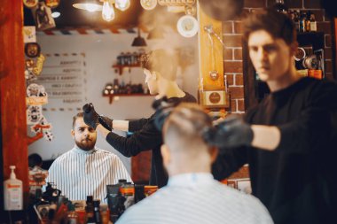 Berber dükkanında oturan şık bir adam.