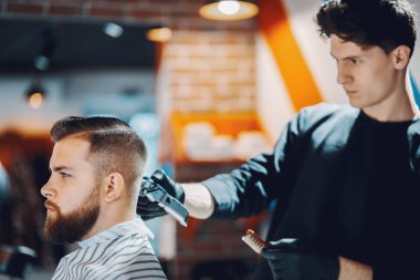 Berber dükkanında oturan şık bir adam.