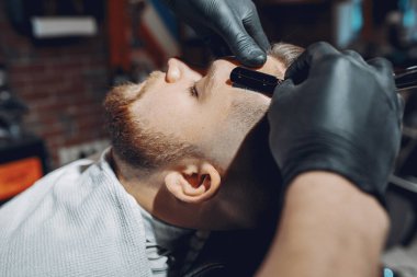 Berber dükkanında oturan şık bir adam.