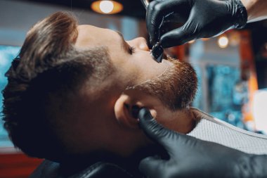 Berber dükkanında oturan şık bir adam.