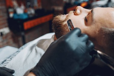 Berber dükkanında oturan şık bir adam.