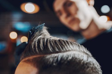 Berber dükkanında oturan şık bir adam.