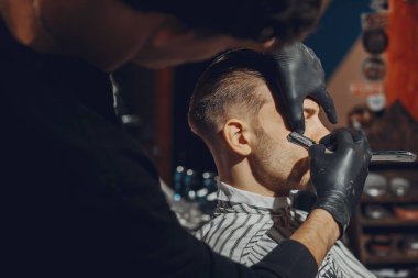 Berber dükkanında oturan şık bir adam.