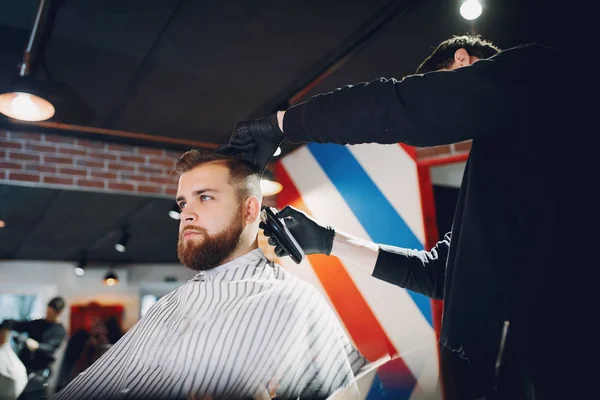 Elegante hombre sentado en una barbería —  Fotos de Stock