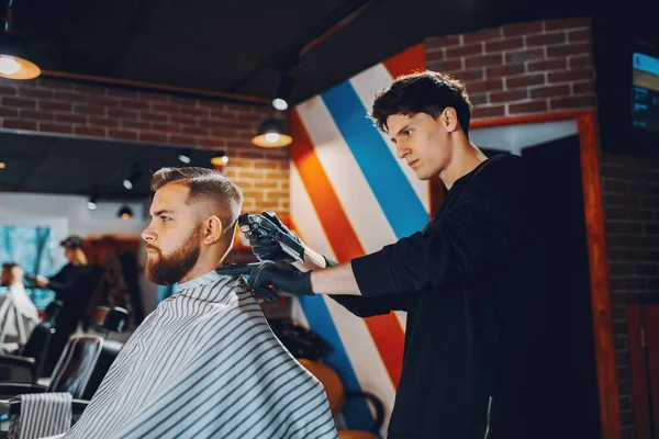 Stilvoller Mann sitzt in einem Friseurladen — Stockfoto