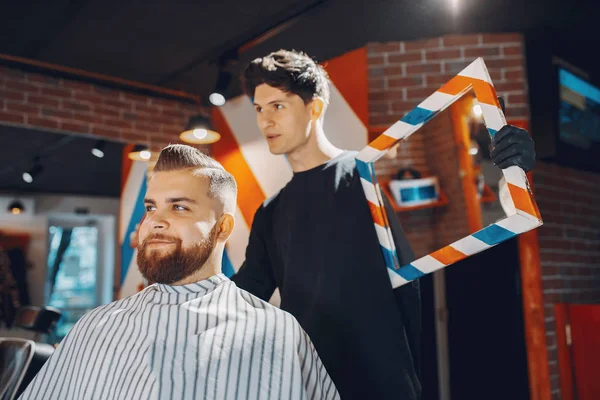 Elegante hombre sentado en una barbería — Foto de Stock