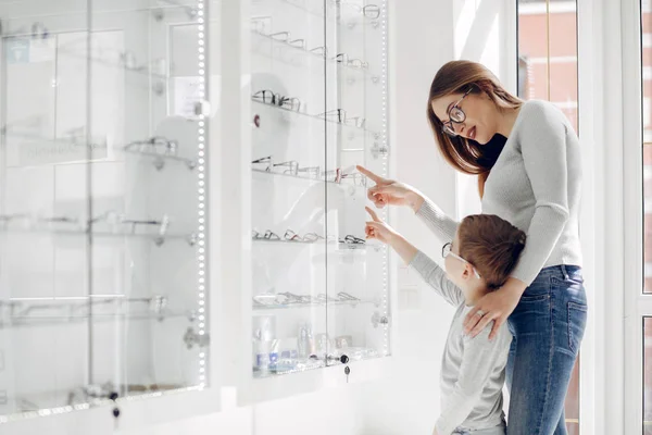 Mamma med liten son i glasögon butiken — Stockfoto