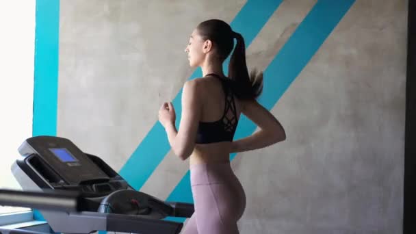 Fit girl running on the treadmil working out — Stock Video