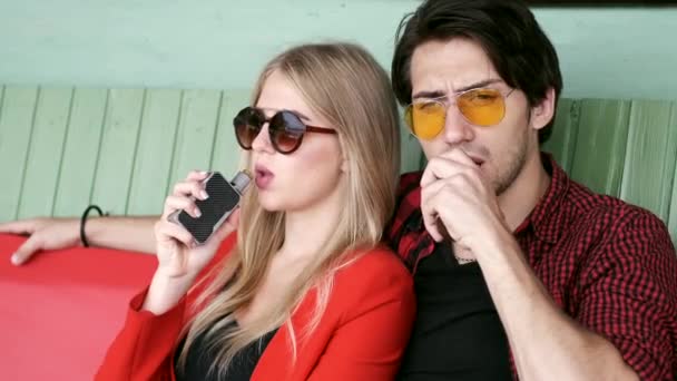 Stylový pár ve městě. Dva lidé používají elektronickou cigaretu — Stock video