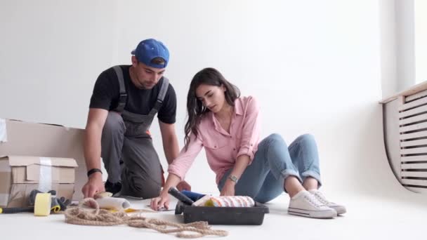 Νεαρό ζευγάρι προετοιμάζεται για την προσαρμογή και τη ζωγραφική τοίχων — Αρχείο Βίντεο