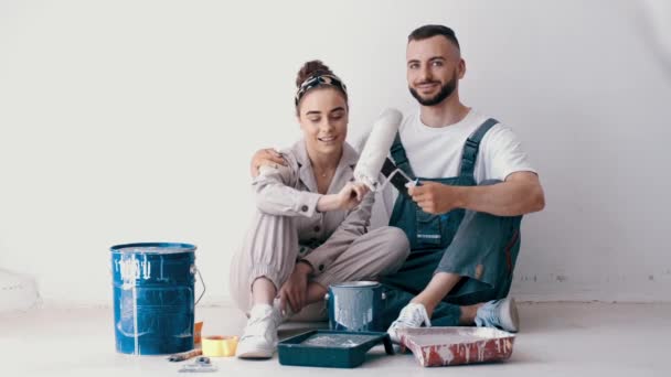 Счастливая пара красит свою первую квартиру вместе — стоковое видео