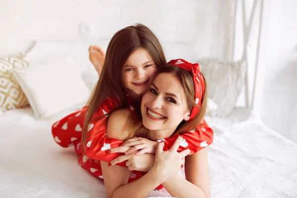 Cute mother and daughter at home in a pajamas — Stock Photo, Image