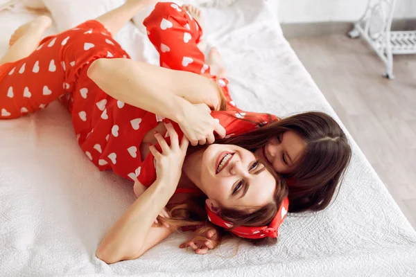 Niedliche Mutter und Tochter zu Hause im Pyjama — Stockfoto